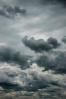 Towering dark clouds rise above a dense, layered gray cloudscape in a brooding sky [IBR125657386]