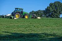 Tractor and large mower of the Köchesldorf agricultural cooperative mowing grass, Othenstorf, Mecklenburg-Western Pomerania, Germany [IBR125657402]