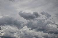 A broad expanse of layered gray storm clouds fills the sky, with darker clouds gathered near the center [IBR125657406]