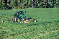 Tractor and large mower of the Köchesldorf agricultural cooperative mowing grass, Othenstorf, Mecklenburg-Western Pomerania, Germany [IBR125657415]