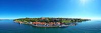 Impressive aerial view in panoramic format of Meersburg on Lake Constance. The historic lower town with its colorful house facades nestles directly against the sparkling water as the upper town, castle, and vineyards sit majestically above. Excursion boat [IBR125659395]