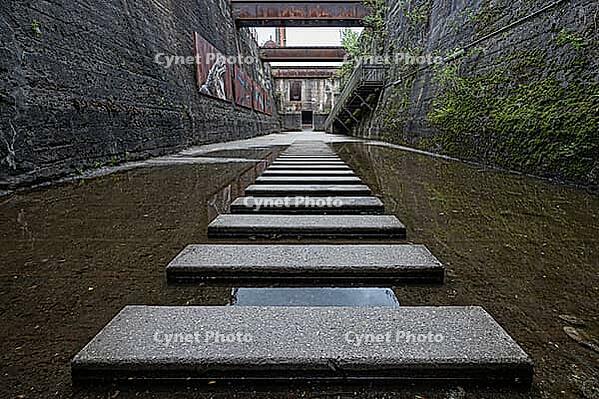 Water-filled tunnel with concrete slabs and graffiti on the walls, Landschaftspark Duisburg-Nord, Duisburg, North Rhine-Westphalia, Germany [IBR123100509]