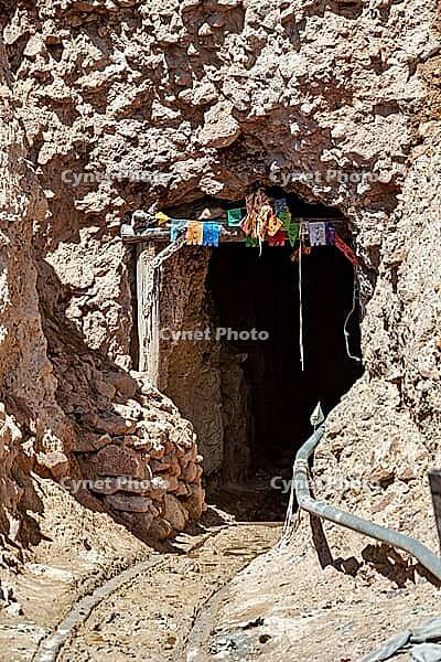 Mine entrance in a rocky landscape decorated with colourful flags, The silver mines of the Cerro Rico silver mountain near Potosi in Bolivia [IBR123416433]