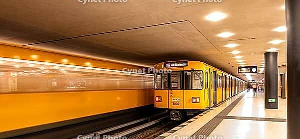 Dynamic scene of a Berlin underground in typical yellow colour, long exposure with blur effect, busy traffic junction at Unter den Linden station, Berlin, Germany [IBR112672610]