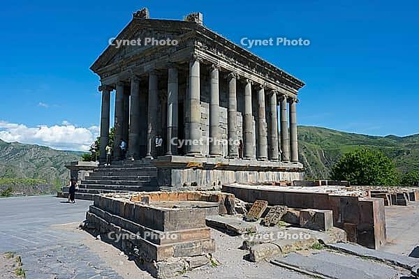 Ancient temple with columns in front of a mountainous landscape under a ...