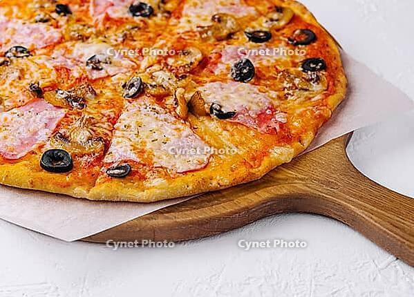 Food, Pizza with ham and mushrooms on a light background [IBR123622454]
