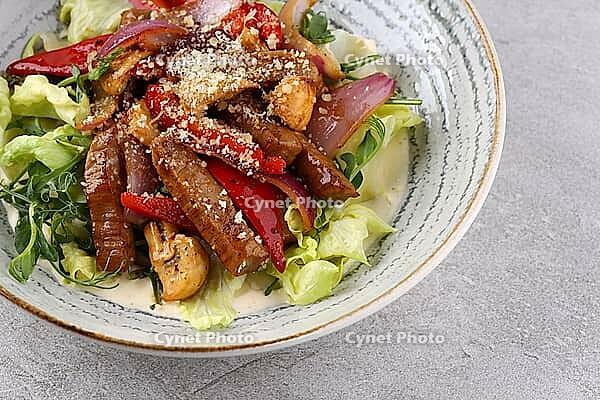 Food, Beef steak salad with cherry tomatoes, cucumbers, red onions, romaine salad and lime mustard olive oil salad dressing on dark background, top view [IBR123622464]