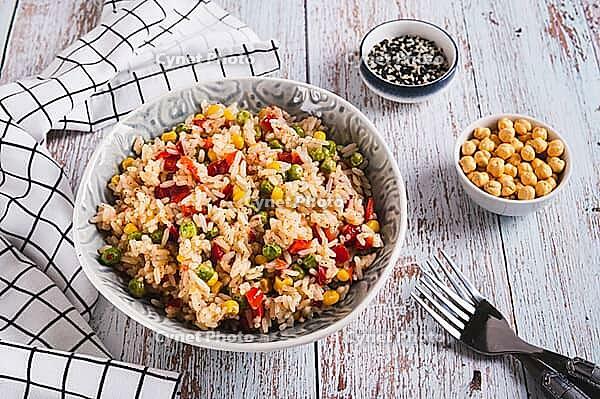 A bowl of cooked rice and vegetables for garnish on the table [IBR123629689]