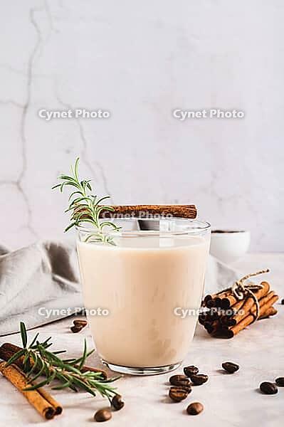 Aromatic coffee with rosemary and cinnamon in a glass on the table vertical view [IBR123629698]