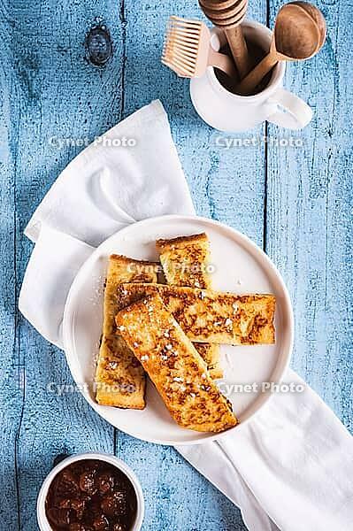 Golden sweet croutons of bread on a plate on the table top and vertical view [IBR123629708]