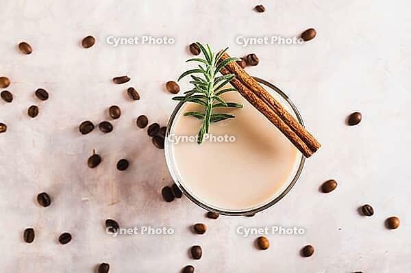 Close up of aromatic coffee with rosemary and cinnamon in a glass on the table top view [IBR123629711]