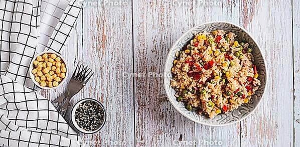 A bowl of cooked rice and vegetables for garnish on the table top view web banner [IBR123629727]
