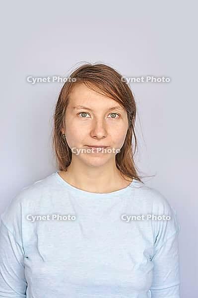 Young caucasian female in light blue shirt against plain background [IBR123629763]