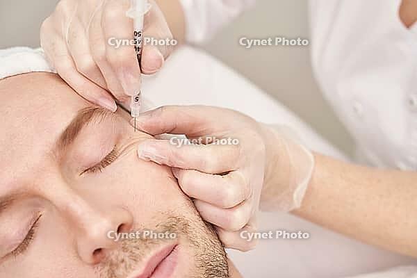 Injection at spa salon. Doctor hands in gloves. Closeup. Pretty male patient. Beauty treatment. Healthy skin procedure. Young man face. Plasmolifting rejuvenation [IBR123638351]