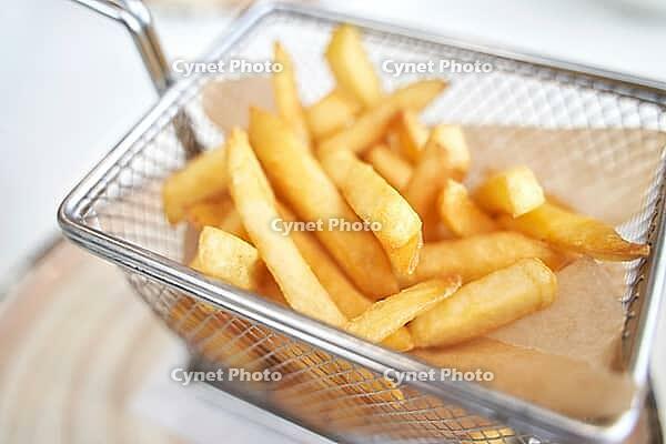 Basket with french fry. Potato chips. Cooking uhealthy lunch. Salty spicy junk. Oil takeaway gastronomy [IBR123638352]