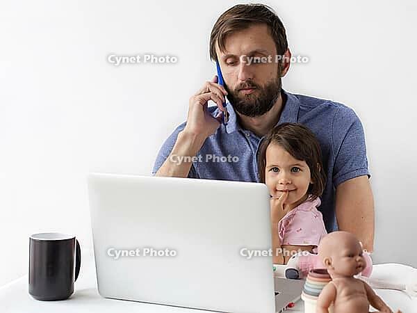 Father working remotely on laptop while talking on phone and spending time with his little daughter at home, multitasking parent lifestyle, family and work balance, fatherhood [IBR123638369]