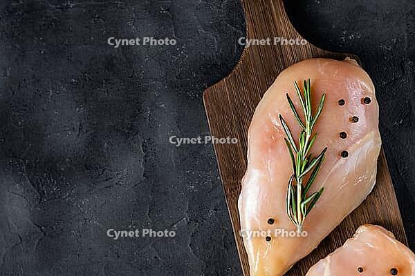 Raw fresh chicken fillet with rosemary and spices on a dark background. Food background, cooking ingredients. Top view with copy space [IBR123639510]