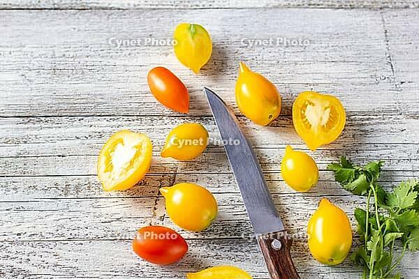 Various colorful ripe tomato on white wooden background. Cooking from yellow orange and red cherry tomatoes. Top view with copyspace [IBR123639564]