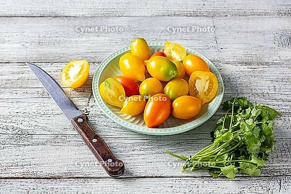 Various colorful ripe tomato on white wooden background. Cooking from yellow orange and red cherry tomatoes. Top view with copyspace [IBR123639566]