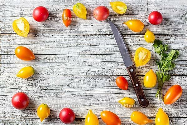 Various colorful ripe tomato on white wooden background. Cooking from yellow orange and red cherry tomatoes. Top view with copyspace [IBR123639569]
