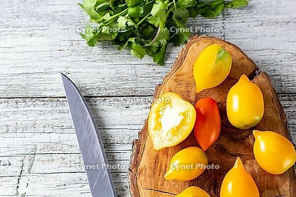 Various colorful ripe tomato on white wooden background. Cooking from yellow orange and red cherry tomatoes. Top view with copyspace [IBR123639570]