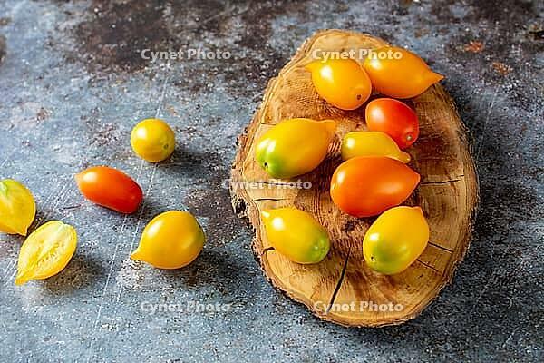 Various colorful ripe tomato on rustic blue background. Cooking from yellow orange and red cherry tomatoes. Top view [IBR123639572]