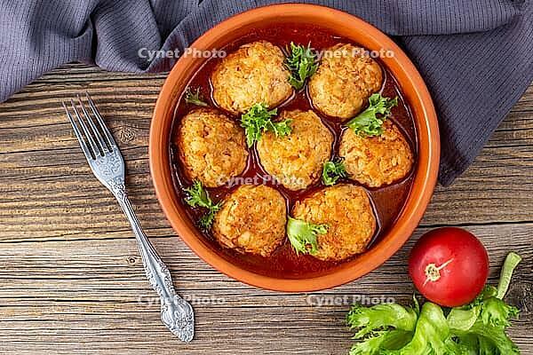 Meatballs in tomato sauce in a bowl on wooden table. Tasty dinner food. Top view [IBR123639576]