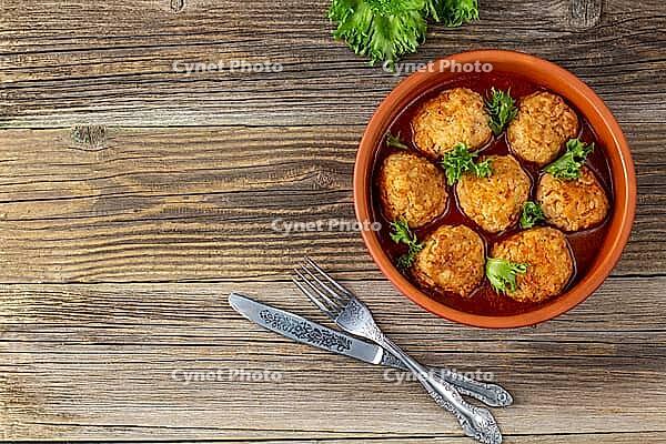 Meatballs in tomato sauce in a bowl on wooden table. Tasty dinner food. Top view copy space [IBR123639577]