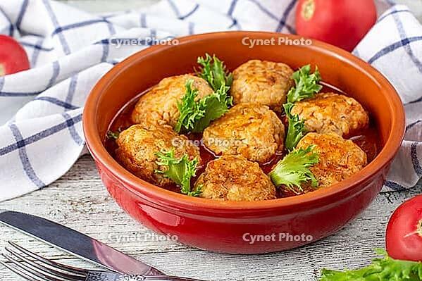 Meatballs in tomato sauce in a bowl on wooden table. Tasty dinner food [IBR123639580]