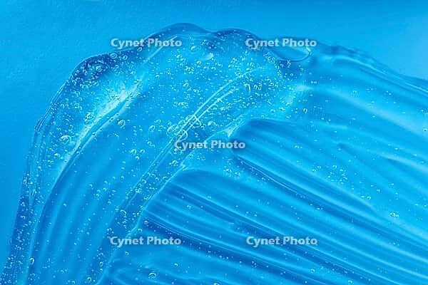 Transparent beauty cosmetic serum product. Hand sanitizer gel texture smear smudge swatch with bubble. Blue moisturizing cleanser, hair gel sample. Skincare makeup cream. Skin care clear liquid splash [IBR123646460]