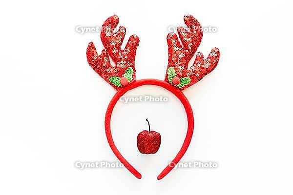 Festive Christmas reindeer made from red decor and headband with reindeer antlers with sequins. Minimal New year Santa creative concept. Flat lay [IBR123646465]