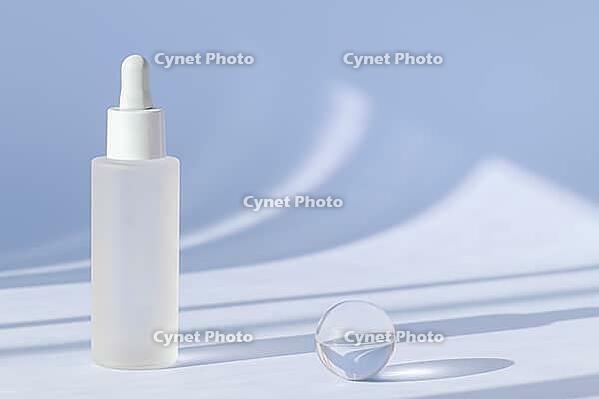 Anti aging serum with collagen and peptides on blue surface with shadows. Hyaluronic acid oil mockup. Sunlight and shadow from serum cosmetic. Transparent liquid product in glass bottle with dropper [IBR123646474]