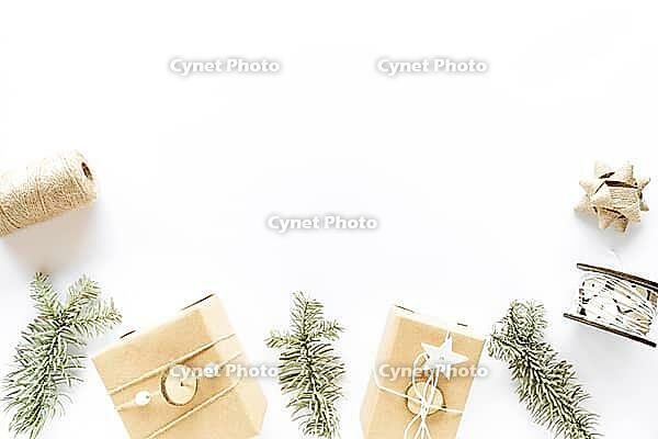 Christmas composition on white surface. Handmade gift boxes, holiday decorations, fir branches. Christmas DIY present concept. Flat lay, top view, copy space [IBR123646483]