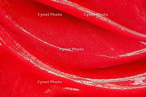 Red gel texture. Cosmetic clear liquid cream smudge. Skin care product sample closeup. Toothpaste or wax background [IBR123646508]
