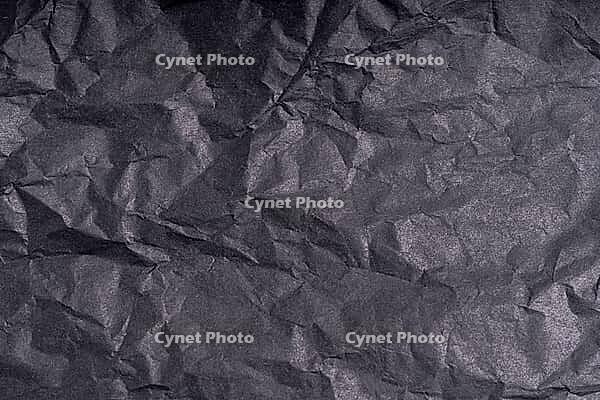 Dark wrinkled creased black paper poster texture. Blank crumpled grainy paper textured surface. Smudged grungy cardboard with fiber. Close up. Material tissue for packing [IBR123646513]