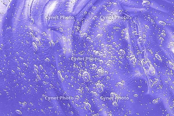 Skincare moisturizing product background. Liquid antibacterial disinfect smear smudge. Cosmetic lilac gel texture with bubbles. Hyaluronic acid clear serum sample. Sanitizer swatch. Close-up, macro [IBR123646517]
