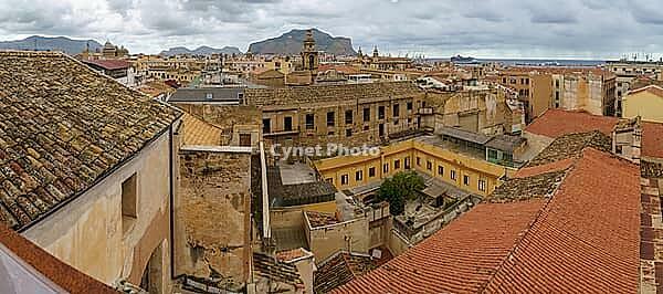Palermo, Italy - 06.11.2022: Panoramic view of historic city rooftops and mountains under cloudy sky [IBR123646534]