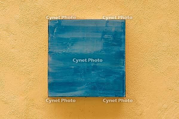 Abstract blue painting on yellow textured wall, minimalist art for modern home decor [IBR123646543]