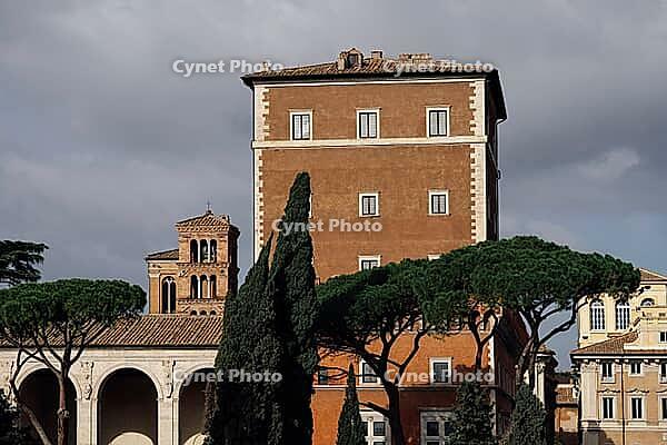 Rome, Italy - 09.12.2022: Ancient roman architecture Palazzo Venezia with tower and cypress trees under cloudy sky [IBR123646548]