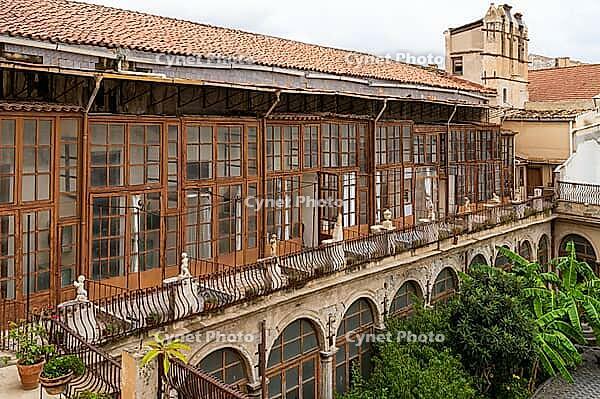 Palermo, Italy - 06.11.2022: Historic colonial architecture with wooden balconies and lush courtyard. Chiostro con fontana di San Domenico [IBR123646551]