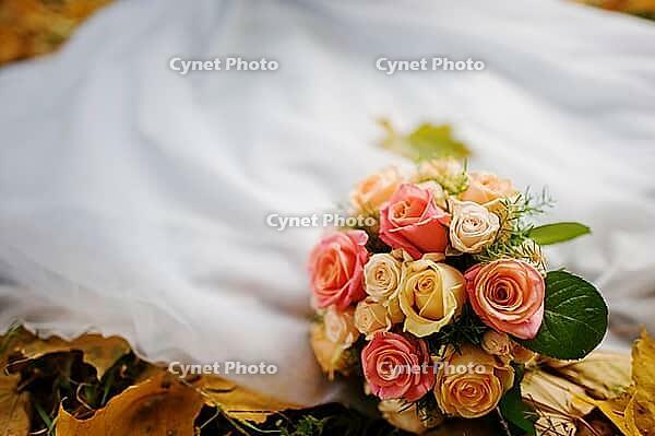 Wedding bouquet background wedding dress in yellow autumn leaves [IBR123675073]