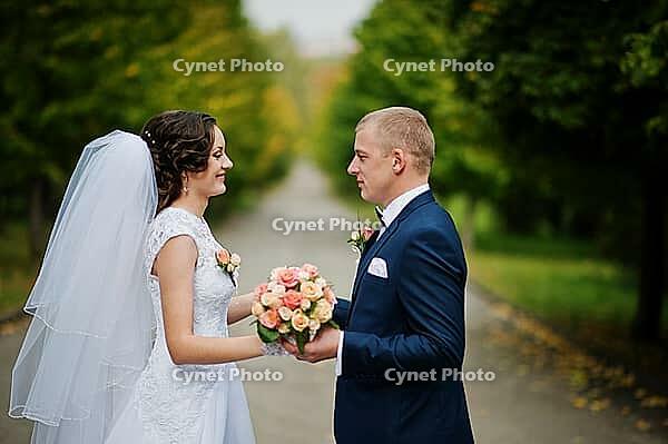 Wedding couple walking at green park [IBR123675115]