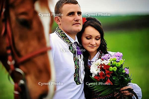 Young couple on national dress with horses [IBR123675138]
