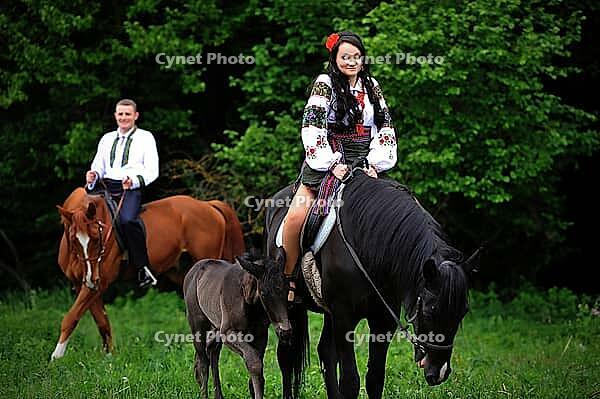Young couple on national dress with horses [IBR123675141]