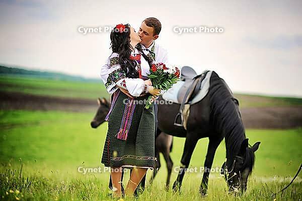 Young couple on national dress with horses [IBR123675142]