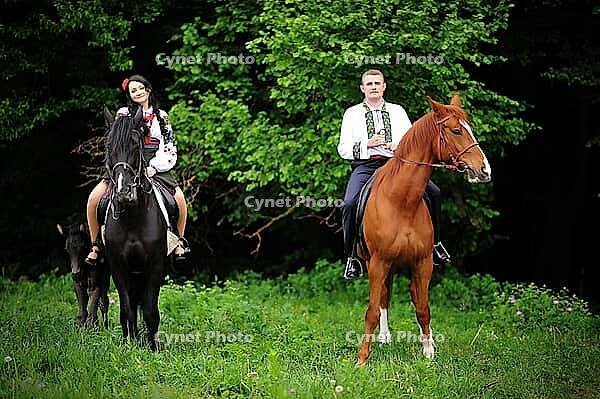 Young couple on national dress with horses [IBR123675144]