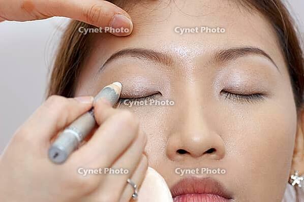 Woman applying cosmetic with applicator. Make-up treatment [IBR123713326]