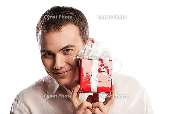 Close-up portrait of smiling man holding gift isolated on white background [IBR123723160]