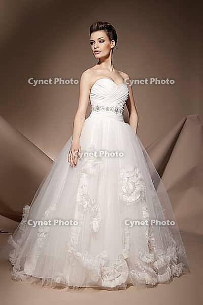 The beautiful young woman posing in a wedding dress [IBR123723171]