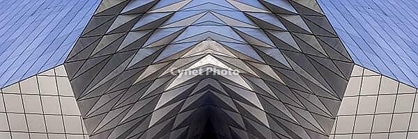 Abstract photography with a symmetrical, diamond-shaped shape that consists of repetitive lines and surfaces in shades of gray, white and blue and creates an impression of rhythm, depth and cool geometric harmony [IBR123760818]